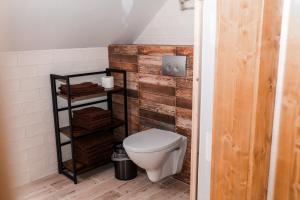 a bathroom with a toilet and a wooden wall at PARKHOUSE in Rožňava