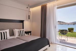 1 dormitorio con cama y ventana grande en Xenia Poros Image Hotel, en Poros