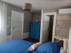 a bedroom with a blue bed and a blue door at VILLA DIAMANTILLES - MAISON D'HOTES in Le Diamant