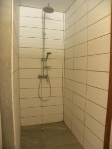 a shower in a bathroom with white tiles at VILLA DIAMANTILLES - MAISON D'HOTES in Le Diamant