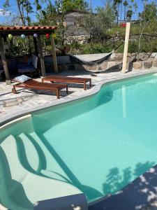 - une piscine avec deux bancs et un kiosque dans l'établissement Quinta do Cobral, à Oliveira do Hospital