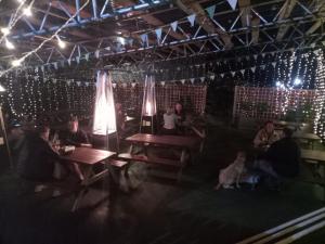 a group of people sitting at tables in a room with lights at The White Swan, Yeadon in Yeadon