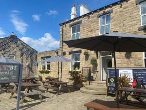 a patio with tables and umbrellas in front of a building at The White Swan, Yeadon in Yeadon