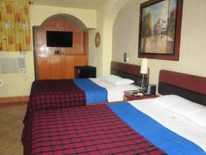 A bed or beds in a room at Hotel Real Azteca