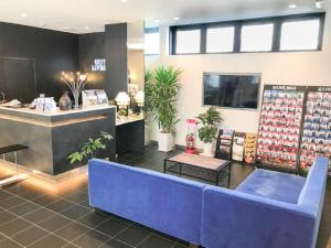 una tienda con un sofá azul delante de un mostrador en HOTEL LiVEMAX Himeji Shiyakusho Mae, en Himeji