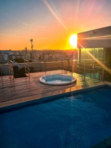 - un bain à remous sur un balcon avec vue sur le coucher du soleil en arrière-plan dans l'établissement Paradiso Corporate, à Cabo Frio