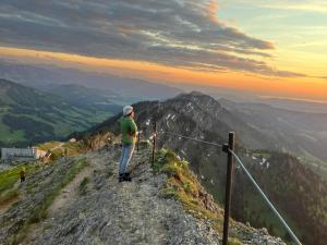 een man die op een berg staat bij Interest Vitalhotel - Partnerbetrieb von Oberstaufen PLUS in Oberstaufen