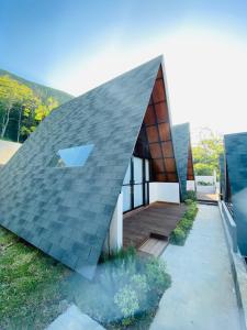 a house with a shingled roof at Bukit Tiga Lima Boutique Hotel in Sajang