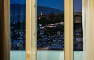 una ventana con vistas a la ciudad por la noche en Patio Rooms Gjirokaster, en Gjirokastra