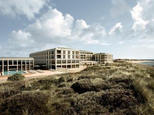 ein Gebäude am Strand neben dem Meer in der Unterkunft A-ROSA Sylt in List