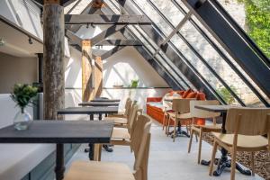 une salle à manger mansardée avec des tables et des chaises dans l'établissement Le Saint-Nicolas, à La Rochelle