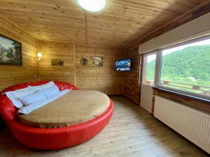 een slaapkamer met een rood bed in een kamer met een raam bij Готель Довбуш in Jaremtsje