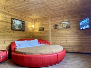 een slaapkamer met een rood bed in een houten kamer bij Готель Довбуш in Jaremtsje