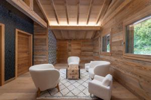 a living room with white chairs and a table at Aigle des Neiges 5 étoiles in Gérardmer