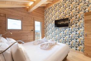 a bedroom with a bed with a tv on a wall at Aigle des Neiges 5 étoiles in Gérardmer