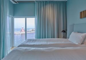 um quarto com uma cama grande e uma janela grande em Scandic Oceanhamnen em Helsingborg