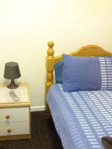 a bedroom with a bed and a lamp on a night stand at Park House B&B in Leeds