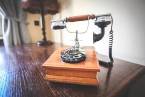 um telefone em cima de uma mesa de madeira em Pension Dáša em Tábor