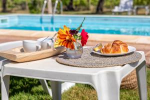 uma mesa com um prato de pão e um vaso de flores em Villa Grazia em Alghero