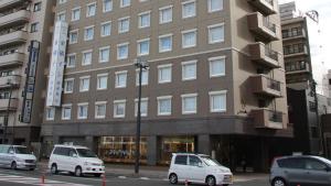 two white cars parked in front of a building at Toyoko Inn Morioka eki Minami guchi Ekimae in Morioka