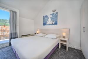 卡什泰拉Hotel Aqua - Guest Rooms & Suites Kaštela的卧室设有一张白色大床和一扇窗户。