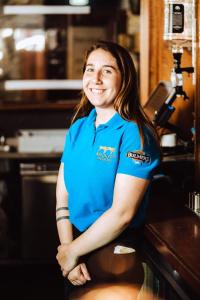 een vrouw in een blauw shirt in een keuken bij Bridge Inn Studio Apartments in Donegal