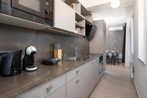 a kitchen with white cabinets and a counter top at Golden Gate apartment in Pula