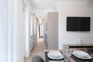 a living room with a table and a tv on a wall at Golden Gate apartment in Pula