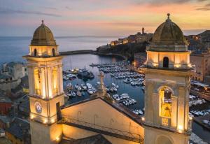 uma cidade com duas torres e um porto à noite em Près du Vieux port Studio terrasse vue dégagée église de Saint Jean em Bastia