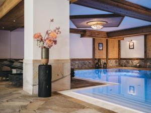 - une piscine avec un vase de fleurs dans un bâtiment dans l'établissement VAYA Seefeld, à Seefeld in Tirol