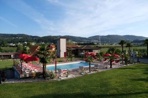 una piscina con sillas y sombrillas en un complejo en Aldeia da Quinta do Paço, en Santo Tirso