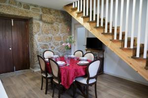 un comedor con mesa y sillas y una escalera en Aldeia da Quinta do Paço, en Santo Tirso