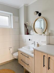 bagno con lavandino, servizi igienici e specchio di Ferienwohnung Swedish Summer a Scharbeutz