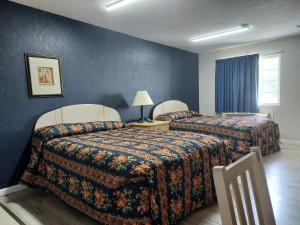 Studio Inn and Suites في غالاوي: سريرين في غرفة فندق بجدران زرقاء