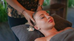 Une femme qui se fait couper les cheveux dans un salon dans l'établissement Uluwatu Cottages, à Uluwatu