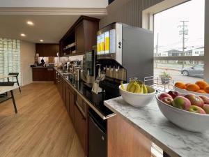 - une cuisine avec un bol de fruits sur un comptoir dans l'établissement Clarion Pointe Quebec Airport, à Québec