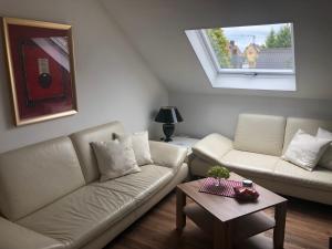 a living room with two white couches and a table at Apartment Sabine in Oberasbach