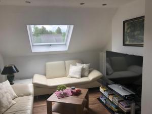 a living room with a white couch and a window at Apartment Sabine in Oberasbach