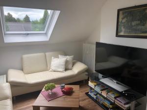 a living room with a couch and a flat screen tv at Apartment Sabine in Oberasbach