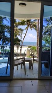 une terrasse avec une table et des chaises et l'océan dans l'établissement Rosy Sea Front Beach Condo, à Bamburi