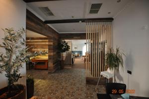 a room with a hallway with a table and some plants at Parkhotel Schwedt in Schwedt