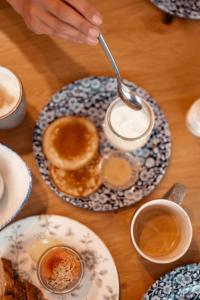 una mesa con un plato de tortitas y tazas de café en Boutique Hotel Villa Monika, en Westerland