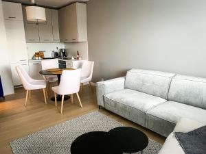 salon z kanapą, stołem i krzesłami w obiekcie Apartament Polanki Aqua A408 w Kołobrzegu