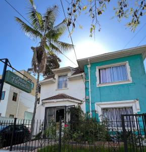 a blue and white house with a palm tree at Hotel Florencia in Viña del Mar