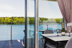 een kamer met een tafel en uitzicht op het water bij Apartamenty Mazurskie Klimaty (Cud Natury) in Tomaszkowo