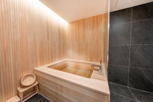 a bathroom with a wooden tub and a shower at Hotel Foret The Spa in Busan