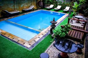 an overhead view of a swimming pool with green grass at Bali 85 Beach Inn in Padangbai