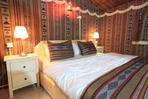 a bedroom with a bed with two night stands and two lamps at بيرحاء إبراء للسياحة in Ibrā