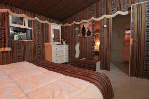 a bedroom with a large bed and a dresser at بيرحاء إبراء للسياحة in Ibrā