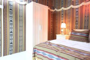 a bedroom with a bed and a wall at بيرحاء إبراء للسياحة in Ibrā